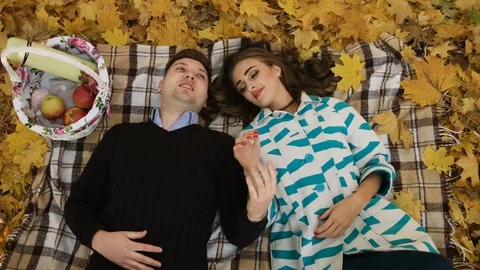 Shoot from above of young couple lying on a fallen autumn leaves in a park Stock Footage 74169000