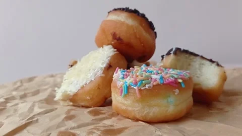 A shoot of four donuts on a brown table Stock Footage 149956534