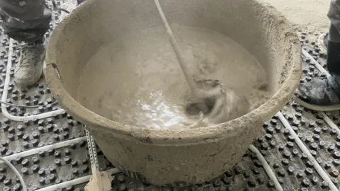 Shoot of mixing concrete using an electric mixer. The worker mixes the mortar Stock-Footage 229499820