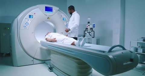 Shoot from side. Multicultural doctor is conducting magnetic resonance imaging Stock Footage 243608786