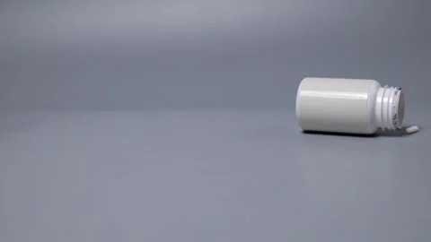 Shoot in slow motion Pills spilling out of pill bottle white and two-colore.. Video stock 256082089