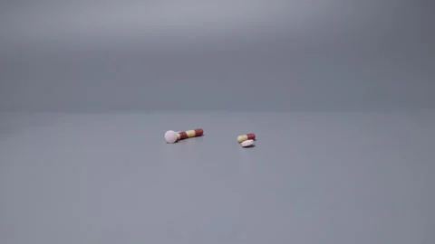 Shoot in slow motion Pills spilling out of pill bottle white and two-colore.. Video stock 256082091