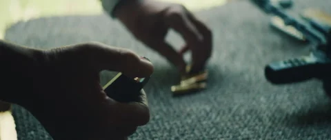 Shooter hand loading magazine with bullets during firearm preparation phase Stockbeeldmateriaal 313093089