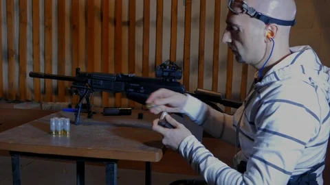 Shooter-man loading a twelve-gauge carbine and firing at targets.  Stock Footage 113294815