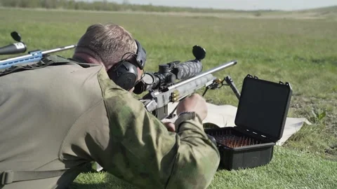 Shooter is preparing for an exercise in high-precision shooting from a rifle Stock-Footage 243798355