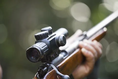 A shooter sighting in the target. Stock Photos
