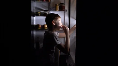 Shooting 4K . A young hungry boy eats at night . Stock Footage 129470070