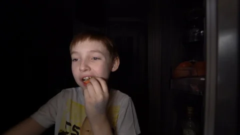 Shooting 4K . A young hungry boy eats at night . Stock Footage 129470074