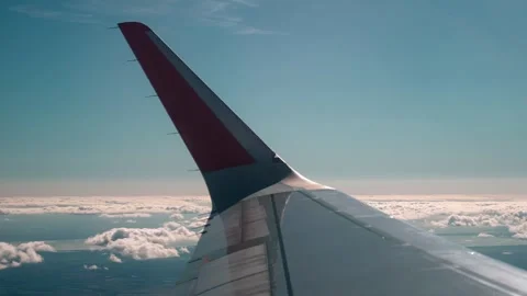 Shooting an airplane wing while flying in the sky above the clouds Stock Footage 252202810