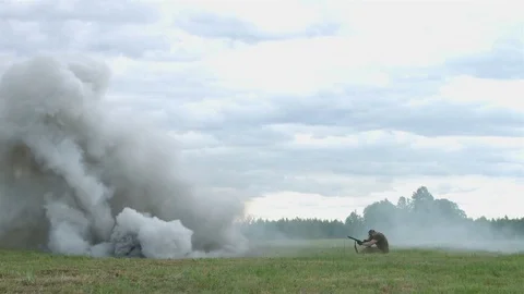 Shooting and explosions. An armed man gets under mortar fire. War Stock Footage 76964477
