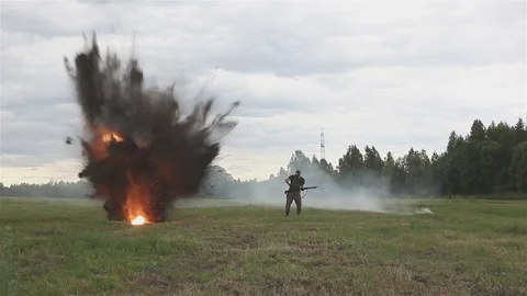 Shooting and explosions. An armed man gets under mortar fire. War Stock Footage