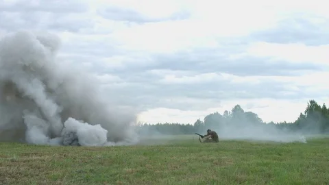 Shooting and explosions. An armed man gets under mortar fire. War Stock Footage 77322631