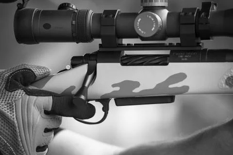 A shooting begins to pull the trigger as he shoots his gun at the rifle range. Stock Photos