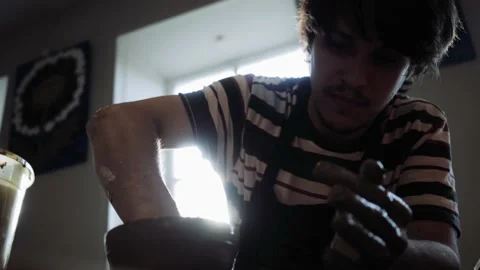 Shooting from the bottom point of a potter working on a potter's wheel. Stock Footage 165031001