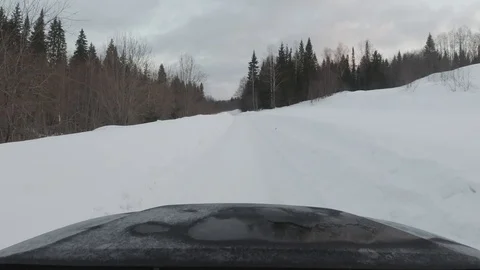 Shooting a car driving along an empty snowy forest road from a windshield Stock Footage 127750311
