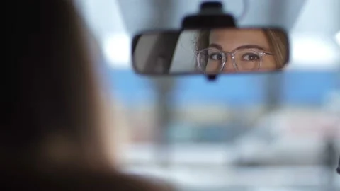 Shooting in the car, reflected in the front mirror. Beautiful female eyes with Video stock 100395084