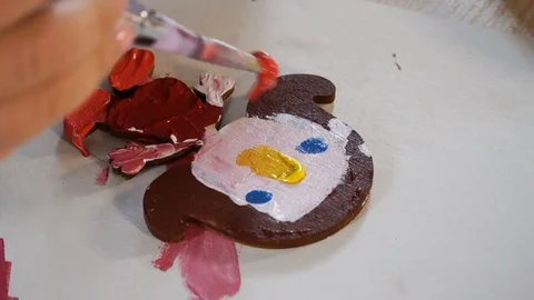 Shooting close-up. Hand of the child, brush. The girl paints wooden dolls. Stock Footage 83817280