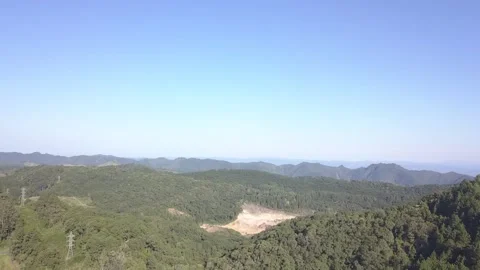 Shooting from drone flying a forest with mountains and power lines.  Stock Footage 154507936