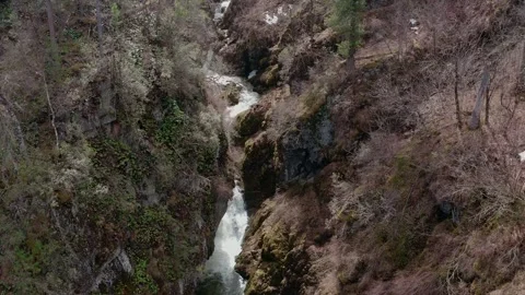 Shooting from a drone flying over a cascading waterfall in the mountains. Stock Footage 327576526