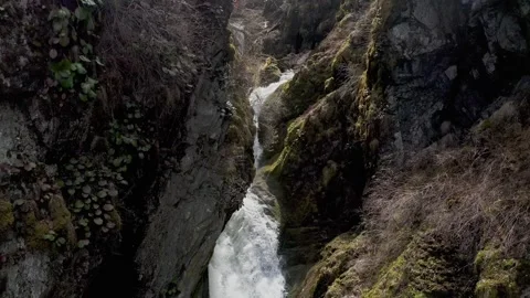 Shooting from a drone flying over a cascading waterfall in the mountains. Stock Footage 327576540
