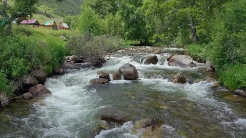 Shooting from a drone flying over a mountain stream and wooded shores. Stock Footage 330059957