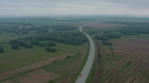 Shooting from a drone flying over a road among fields. . Stock Footage 331941553