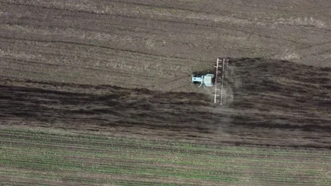 Shooting from drone flying over tractor plowing field, early spring, top view Stock Footage 152873703