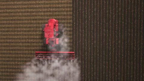 Shooting from drone flying over tractor with harrow system plowing ground on cul Stock Footage 154864617