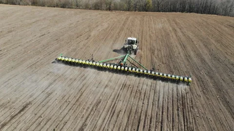 Shooting from drone flying over tractor with harrow system plowing ground on Stock Footage 187163666