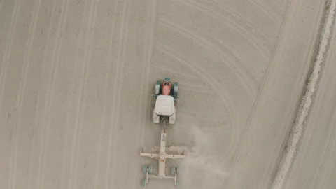 Shooting from drone flying over tractor with harrow system plowing ground on Stock Footage 234096626