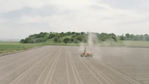 Shooting from drone flying over tractor with harrow system plowing ground on Stock Footage 234096833