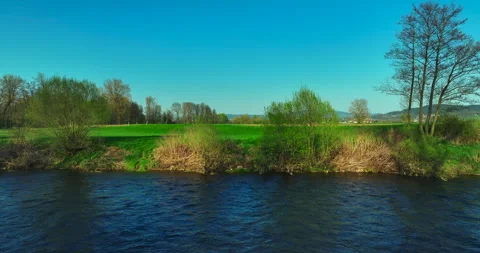 Shooting from a drone . River. Spring. Sunny weather. Green grass. Stock Footage 322681373
