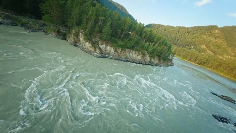 Shooting from a dynamic FPV drone. A flight over a bubbling mountain river with Stock Footage 278366371