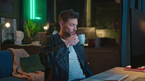 Shooting of good-looking bearded thoughtful young man drinking tea while sitting Stock Footage 238740467