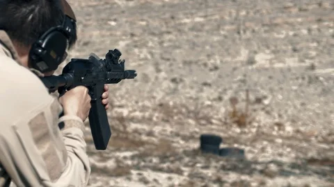 Shooting instructor shooting a shot at the target on the range in slow motion Stock Footage 102661706