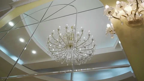 Shooting a large light chandelier through the reflection in the mirror. Stock Footage 139785459