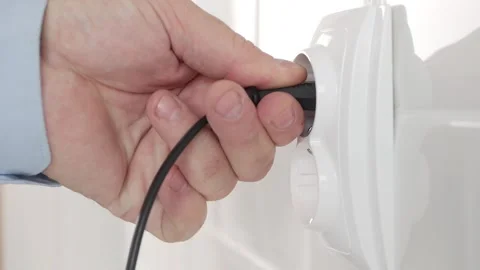Shooting with a Man Connecting a Plug to an Electrical Outlet, Powering with Stock Footage 312120094