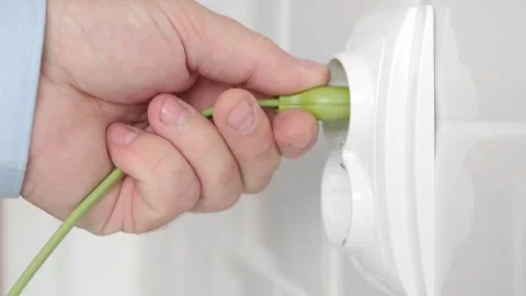 Shooting with a Man Disconnecting a Plug from the Electrical Outlet, Powering Stock Footage 335516386