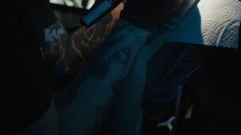 Shooting of man doing dark tattoo of snake on woman Stock Footage 124273322