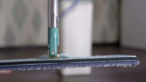 Shooting in motion close-up, the hostess takes a mop for and wipes the floor Stock Footage 153905914