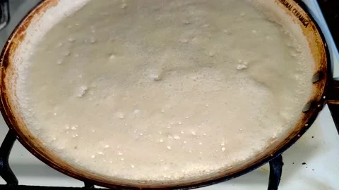 Shooting the preparation of a fried pancake on a black pan.  Cooking pancakes Stock Footage 232945722