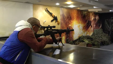 Shooting range. A man in glasses aims and shoots from a Kalashnikov assault Stock Footage 100606837