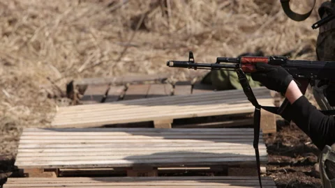 On a shooting range, a men is using a machine gun to fire a target at the 動画素材 201038727