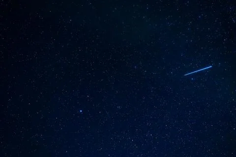 Shooting star meteorite comet on background of a blue starry sky with Stock Photos