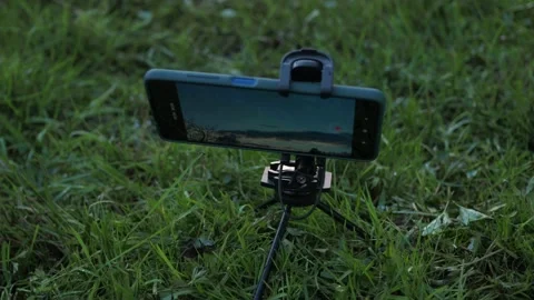 Shooting a sunset on your smartphone. the phone on the tripod takes a timelapse Stock Footage 158634026
