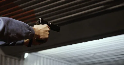 Shooting targets in a range. A closeup of a pistol in his hand. one can see the Stock Footage 86236071