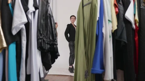 Shooting through a rack of clothes ready for the photo shoot Stock Footage 108376190