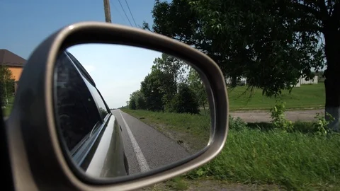 Shooting through the side mirror of the car. The car moves through the Video stock 114889685