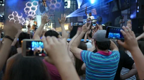 Shooting video of concert performance via smart phone staying in crowd by stage Stock Footage