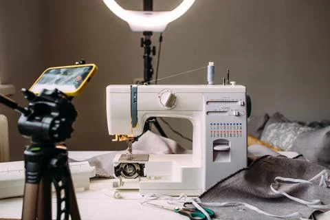 Shooting video of the sewing process, workshop on clothing design on smartphone Fotos Stock